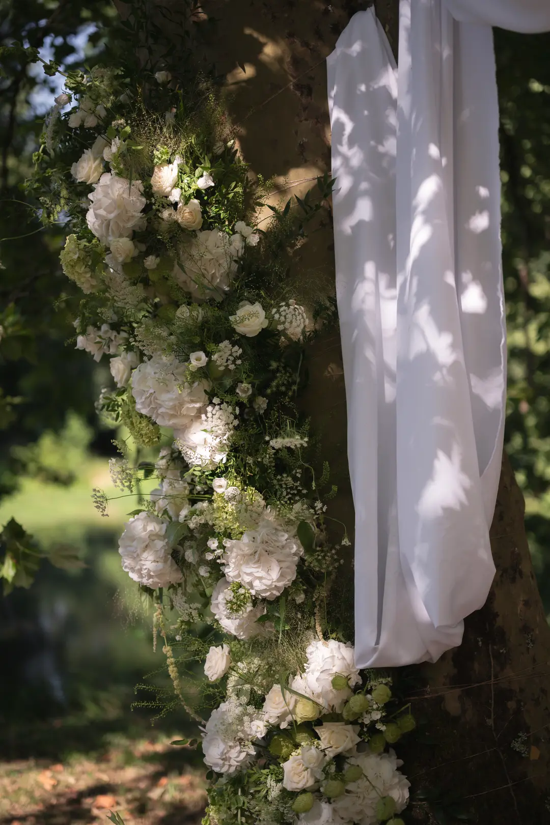 guirlande de fleurs sur un arbre – mariage Emily & Greg, Château Le Thil