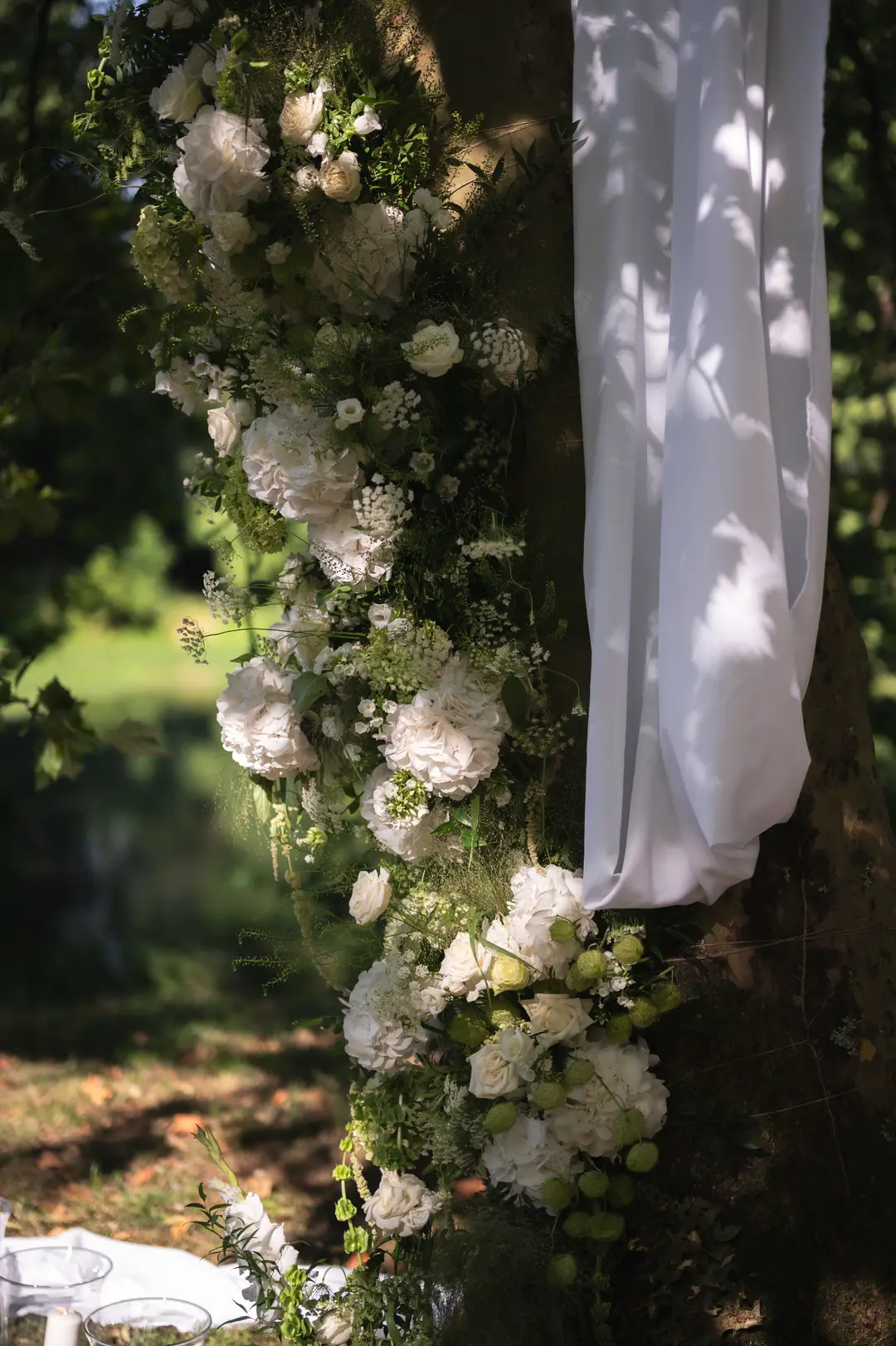 guirlande de fleurs sur un arbre – mariage Emily & Greg, Château Le Thil